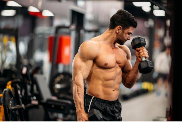 Gym mistakes overtraining. Male doing dumbbell curls